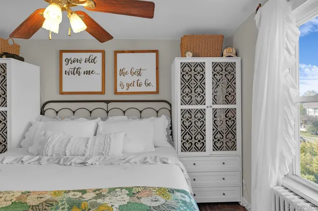 a bedroom with a bed and a flat tv screen on dresser