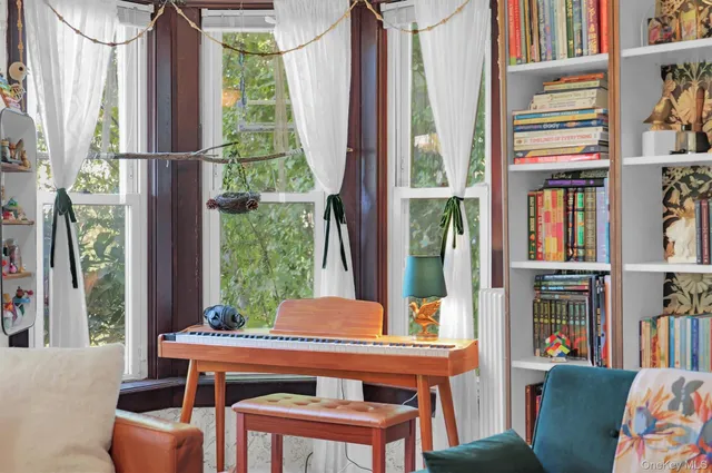 a living room with furniture a bookshelf and a window