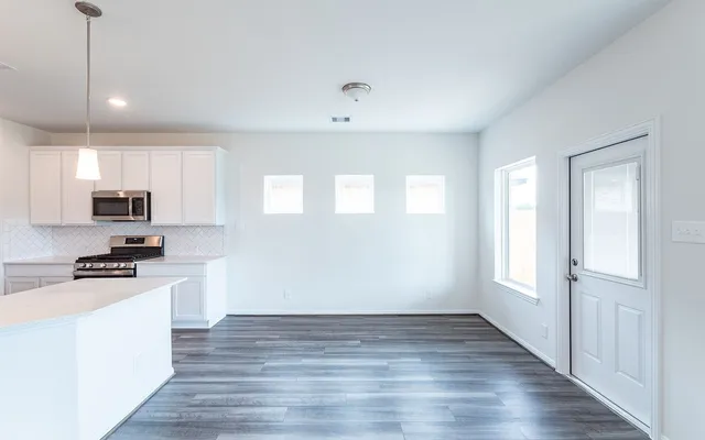 a kitchen with stainless steel appliances a white cabinet and a stove top oven