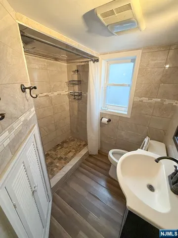 a bathroom with a sink a toilet a mirror and shower