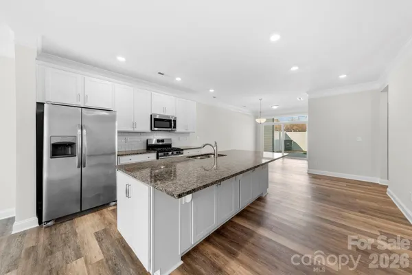 a kitchen with stainless steel appliances granite countertop a refrigerator and a sink