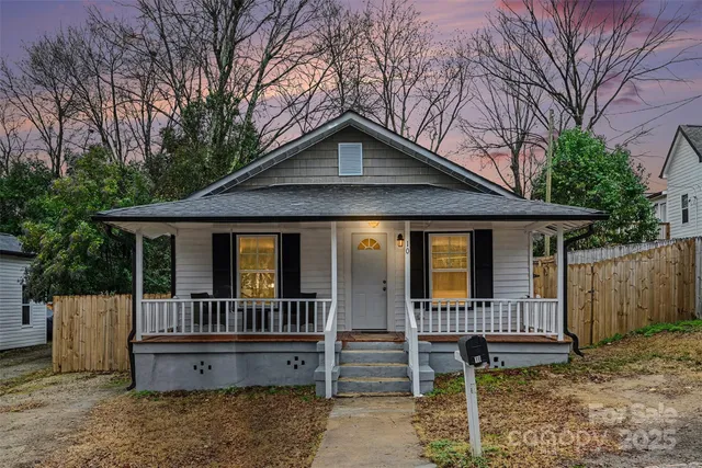 a view of a house with a yard and wooden fence