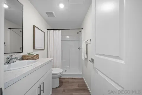 a bathroom with a sink a toilet and shower