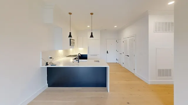 a view of kitchen with kitchen island a sink a stove and a refrigerator