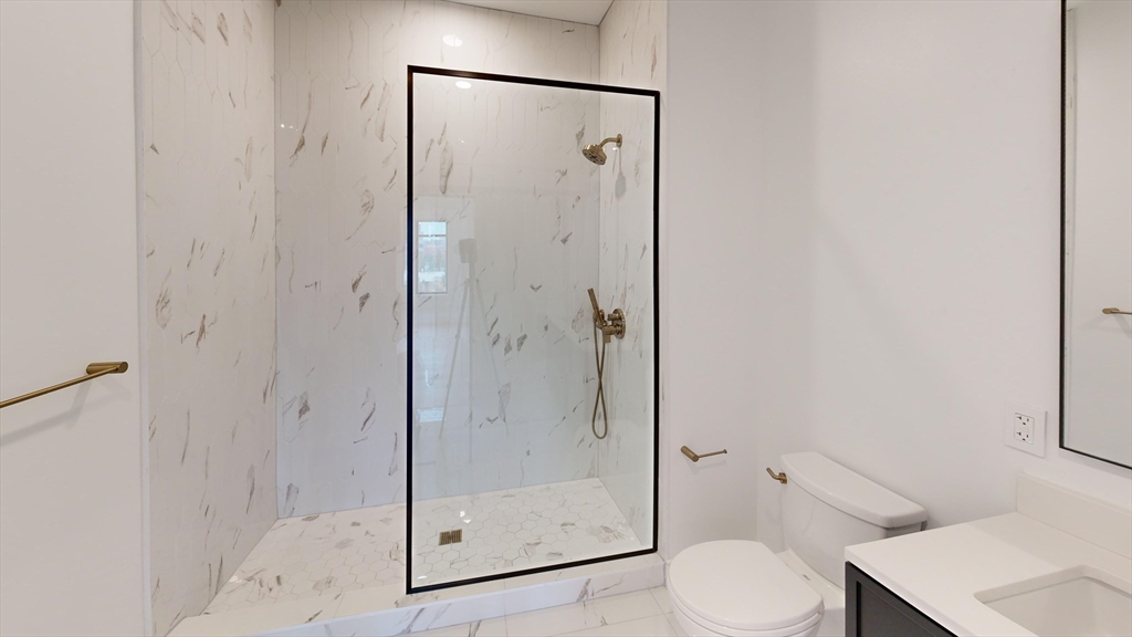 50 Leo M Birmingham Parkway, Unit 506 Boston, MA 02135 - Photo 6 of 10 a bathroom with a shower a toilet and a sink