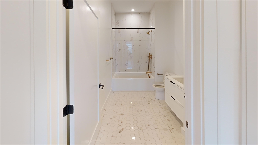 50 Leo M Birmingham Parkway, Unit 506 Boston, MA 02135 - Photo 7 of 10 a bathroom with a bathtub and shower