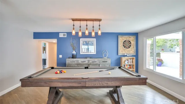 a living room with furniture pool table and a large window