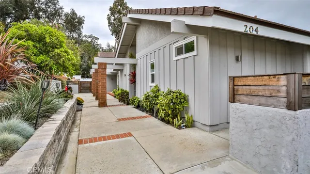 a front view of a house with outdoor seating and plants