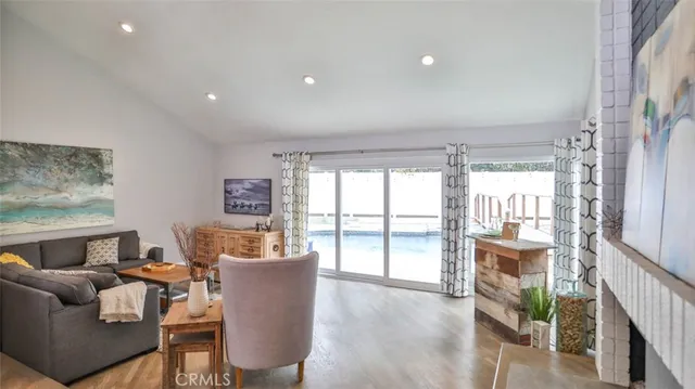 a living room with furniture kitchen view and a large window