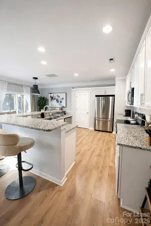 a living room with granite countertop furniture and a dining table with kitchen view