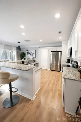 a living room with granite countertop furniture and a dining table with kitchen view