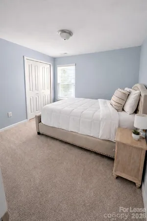 a large bed sitting in a bedroom next to a window