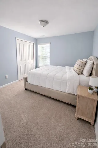 a large bed sitting in a bedroom next to a window