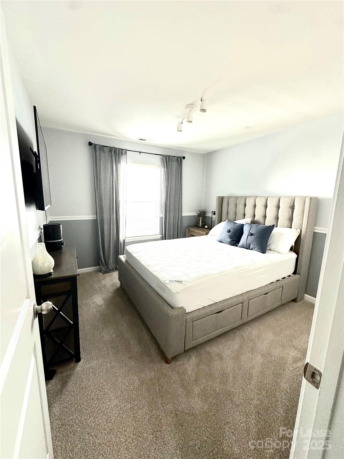 16732 Prairie Falcon Lane Charlotte, NC 28278 - Photo 10 of 18 a bedroom with a bed and a flat screen tv