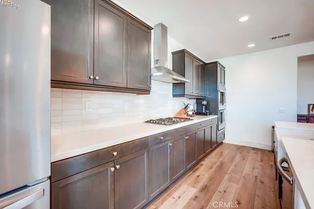 a large kitchen with stainless steel appliances granite countertop a stove a sink and a refrigerator