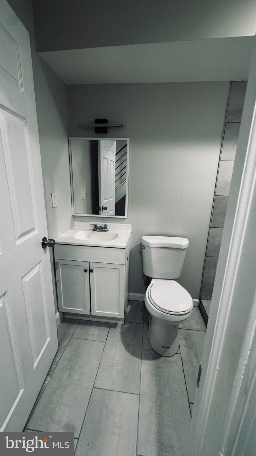 228 South Edgewood Street, Unit 1 Philadelphia, PA 19139 - Photo 5 of 6 a bathroom with a toilet sink and mirror