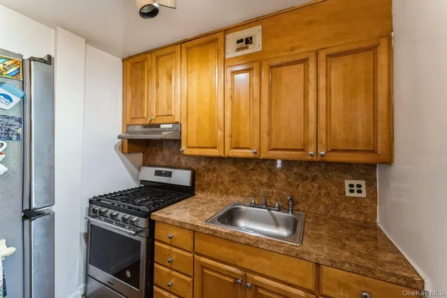 a kitchen with granite countertop cabinets stainless steel appliances and a window
