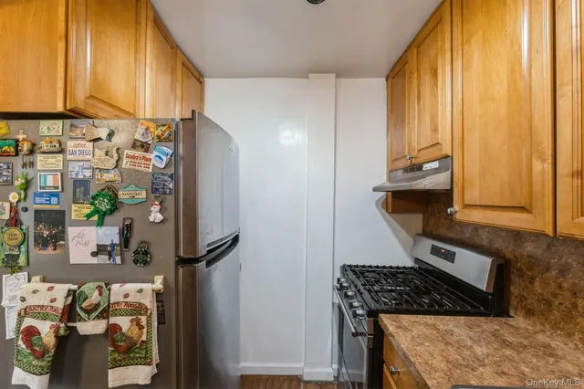 a kitchen with stainless steel appliances granite countertop a refrigerator and a stove