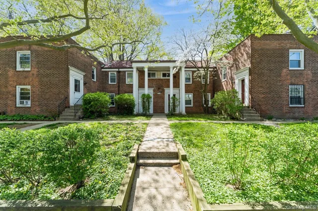 front view of a brick house with a yard