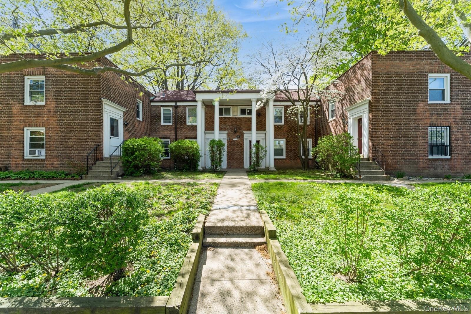 149-32 Union Turnpike, Unit 24A Queens, NY 11367 - Photo 18 of 18 front view of a brick house with a yard