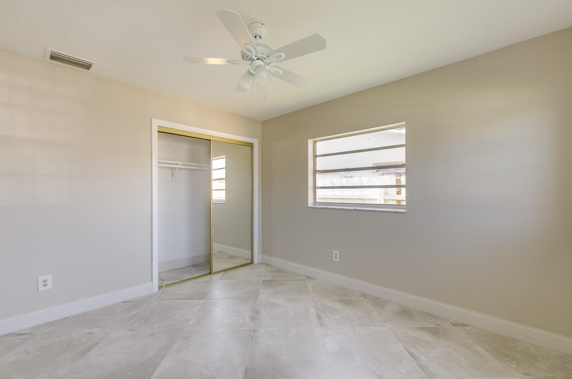 22710 Family Circle Boca Raton, FL 33428 - Photo 19 of 28 an empty room with chandelier fan and windows