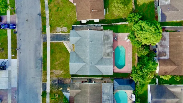 an aerial view of residential house with outdoor space and swimming pool