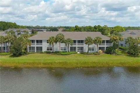a view of a big house with a big yard and large trees