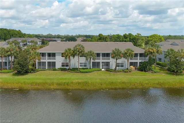 a view of a big house with a big yard and large trees
