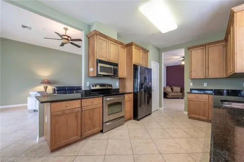 a kitchen with kitchen island granite countertop a stove top oven microwave and cabinets