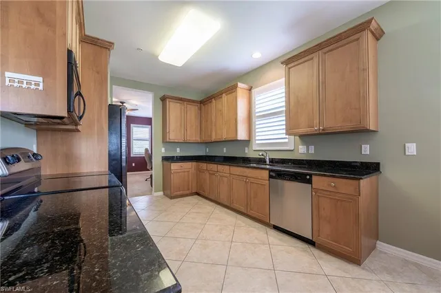 a large kitchen with granite countertop a stove a sink dishwasher and a refrigerator