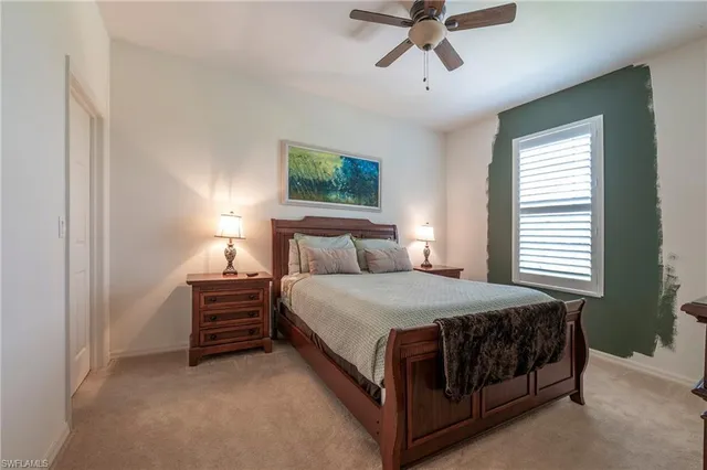 a bed sitting in a bedroom next to a window and a chandelier