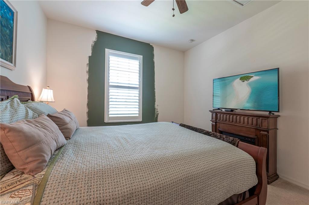 16550 Goldenrod Lane, Unit 201 Fort Myers, FL 33905 - Photo 28 of 45 a bedroom with a bed and a flat screen tv