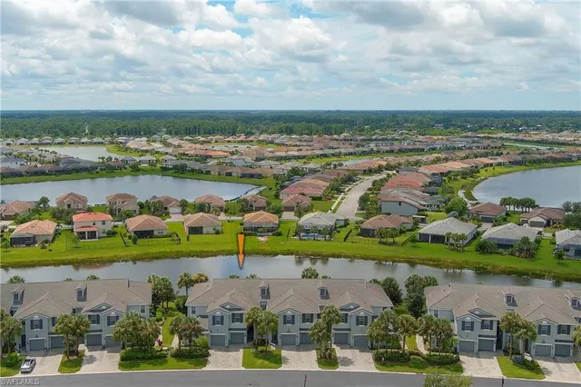 an aerial view of a city with lots of residential buildings ocean and mountain view in back
