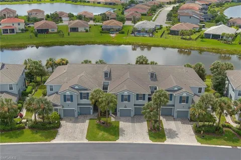 an aerial view of a house with a yard and lake view