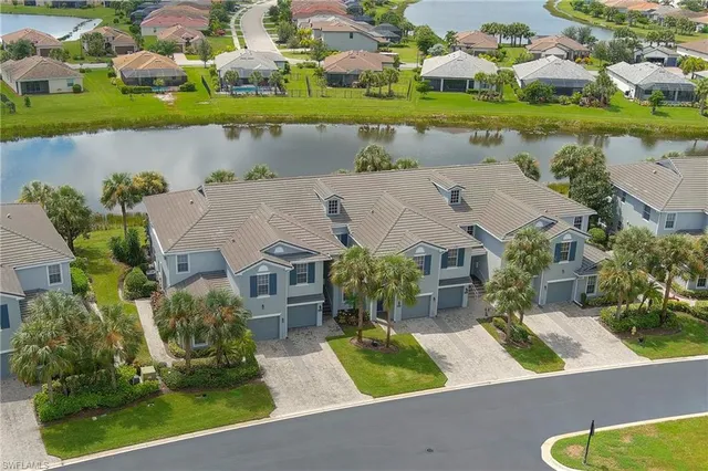 an aerial view of residential houses with outdoor space and parking