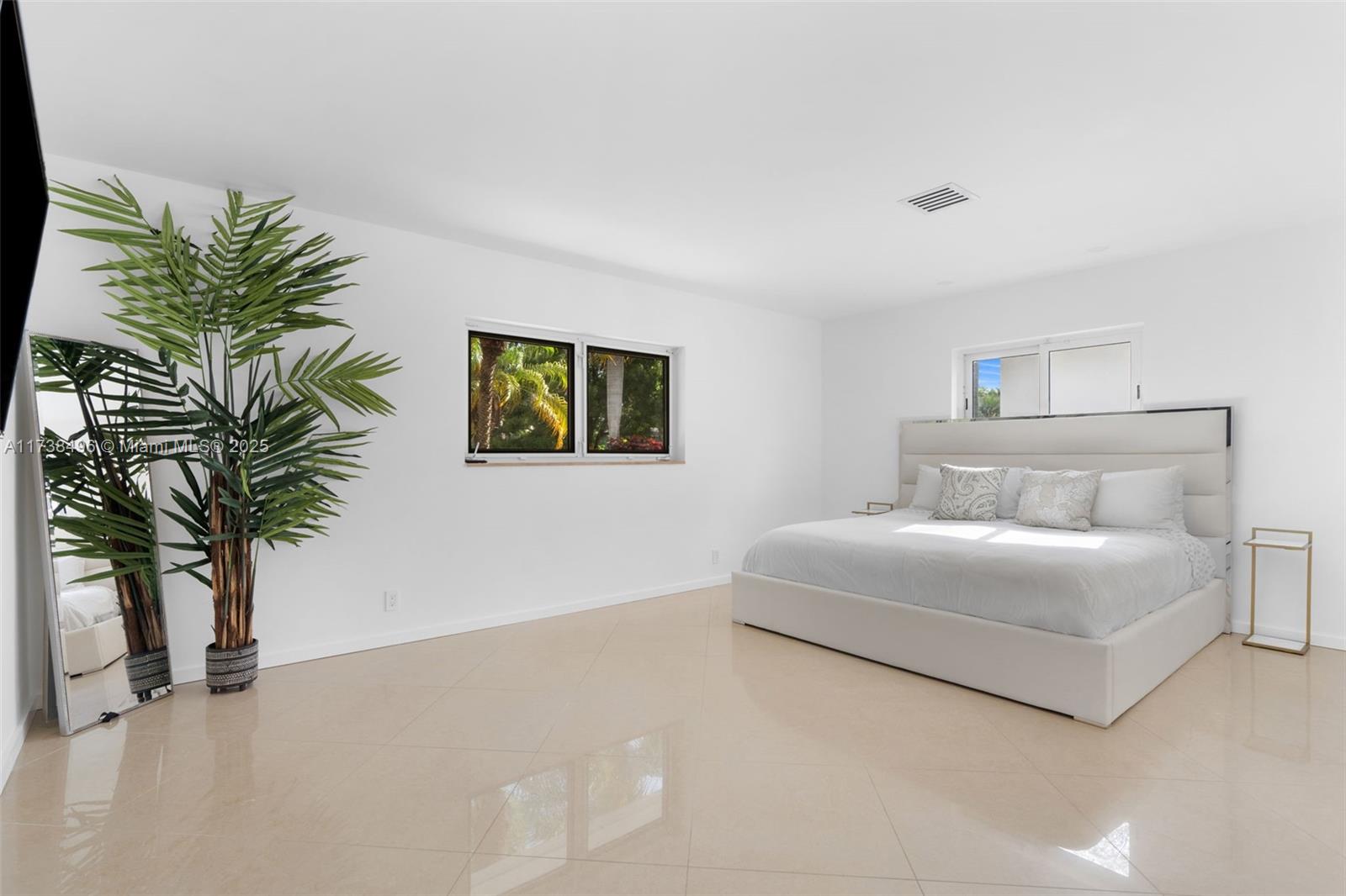 1144 Adams Street Hollywood, FL 33019 - Photo 16 of 51 a bedroom with a large bed and a potted plant
