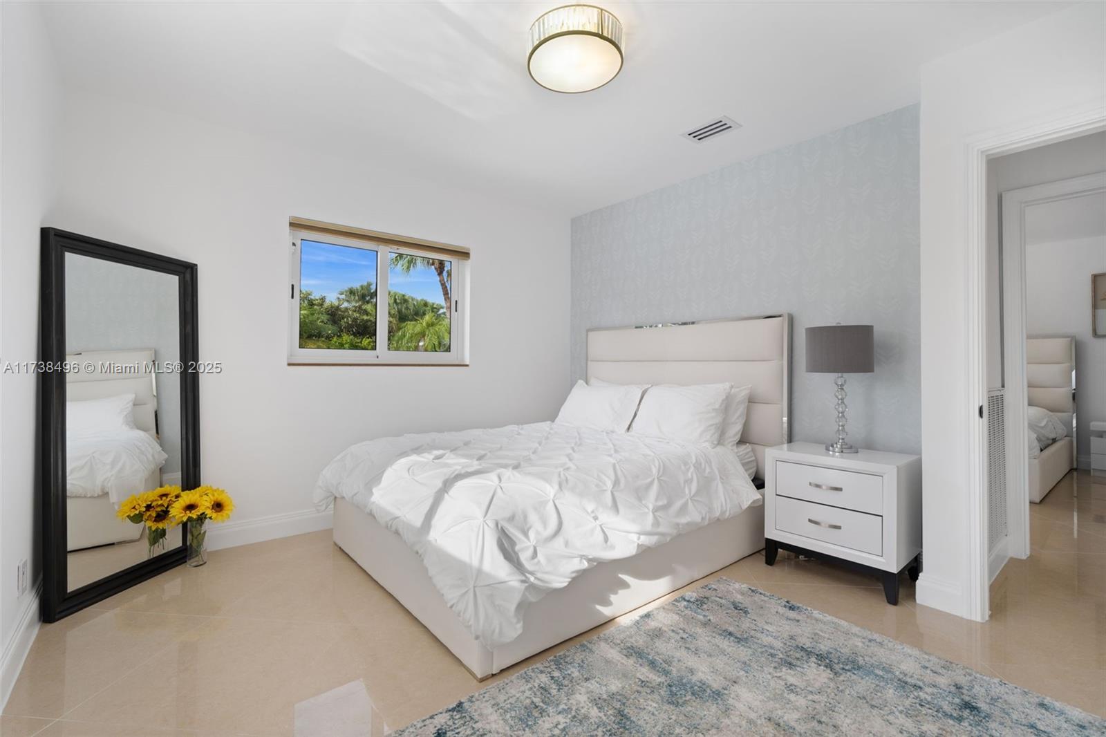 1144 Adams Street Hollywood, FL 33019 - Photo 30 of 51 a bedroom with a bed and a chandelier