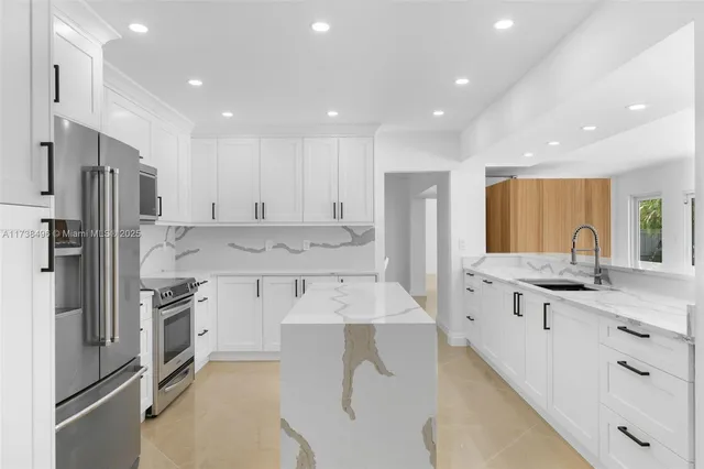 a large kitchen with stainless steel appliances lots of counter space and a sink