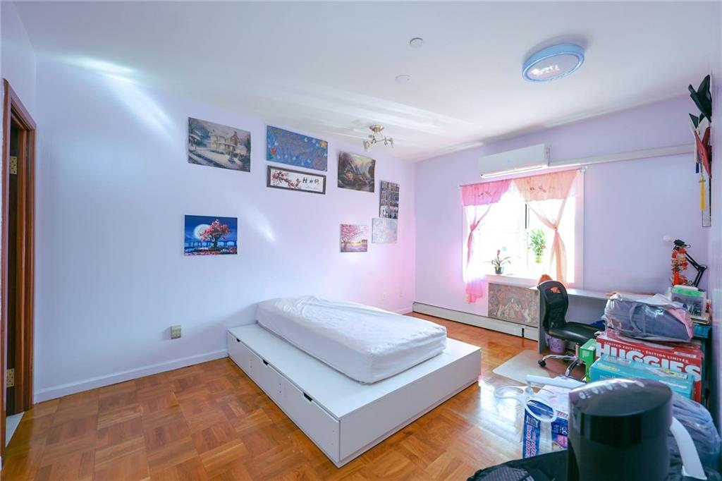 1663 West 6th Street, Unit 3B Brooklyn, NY 11223 - Photo 9 of 16 a spacious bedroom with a bed a table and a window