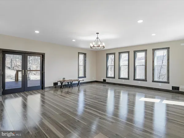 a view of an empty room with window and closet area