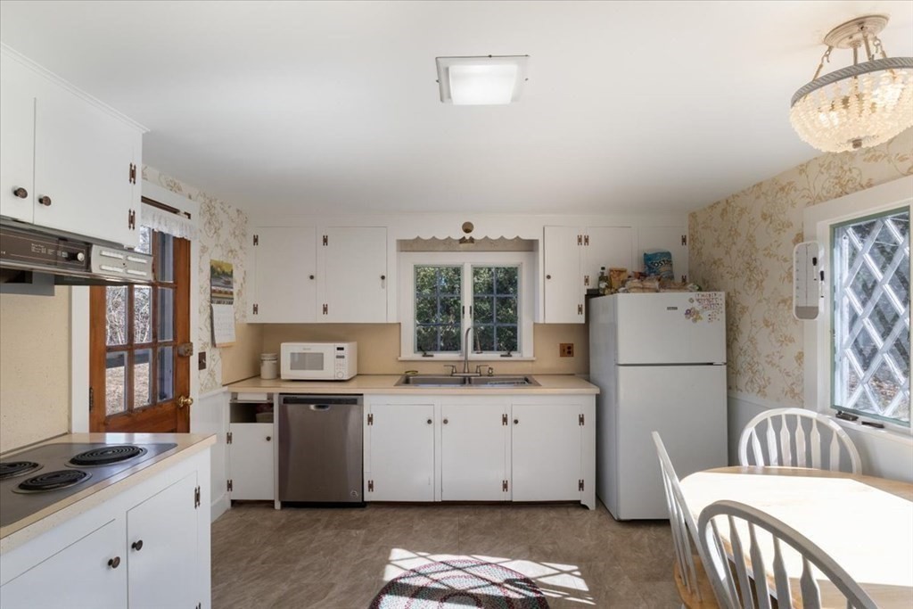 157 Daniels Island Road Mashpee, MA 02649 - Photo 13 of 41 a kitchen with a refrigerator a stove top oven a sink and cabinets