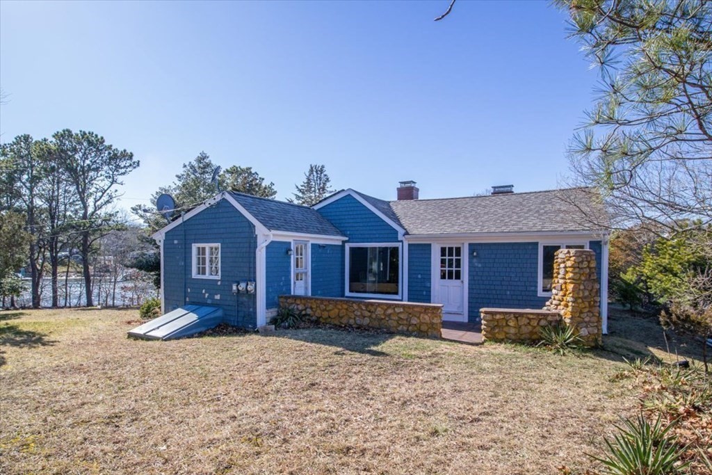 157 Daniels Island Road Mashpee, MA 02649 - Photo 5 of 41 a front view of a house with a yard and large trees