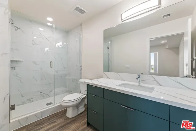 a bathroom with a sink a toilet and shower