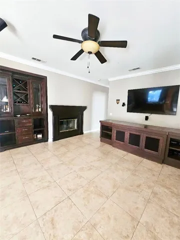a living room with stainless steel appliances kitchen island furniture and a flat screen tv