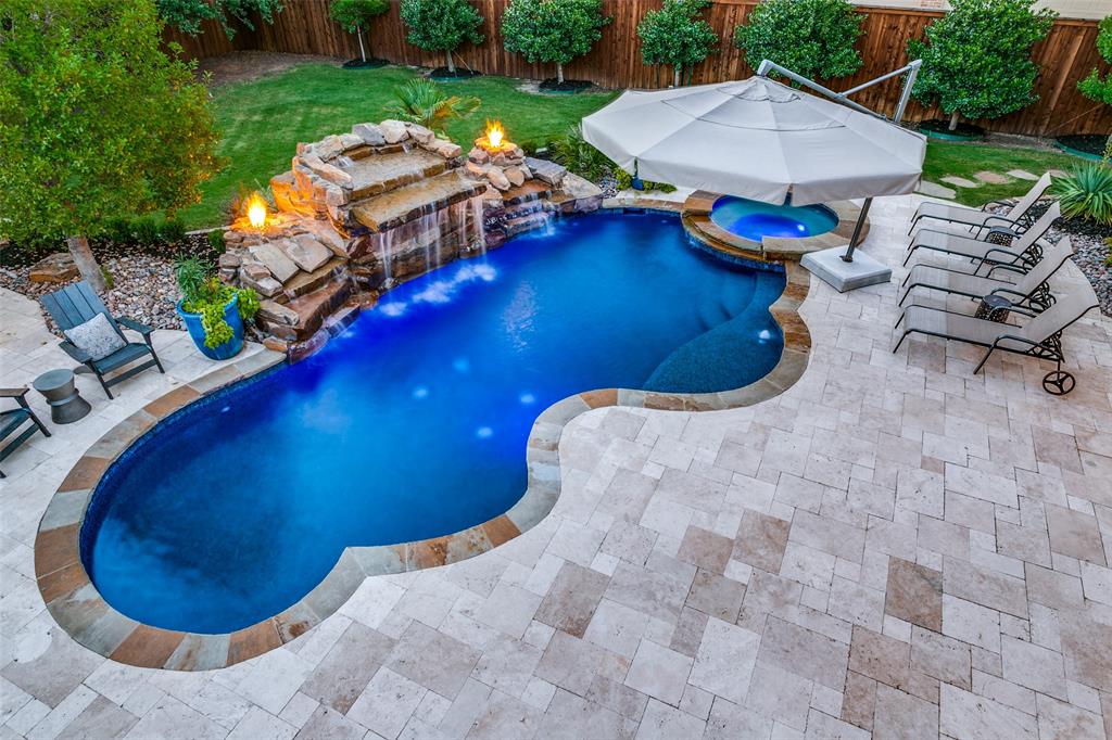 a view of a swimming pool with lawn chairs and a fire pit