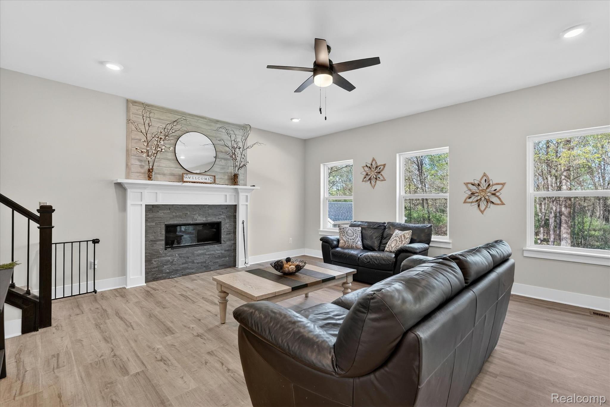 8130 Hinchey Road Pinckney, MI 48169 - Photo 6 of 62 Living room with ceiling fan, a glass covered fireplace, light wood finished floors, and recessed lighting