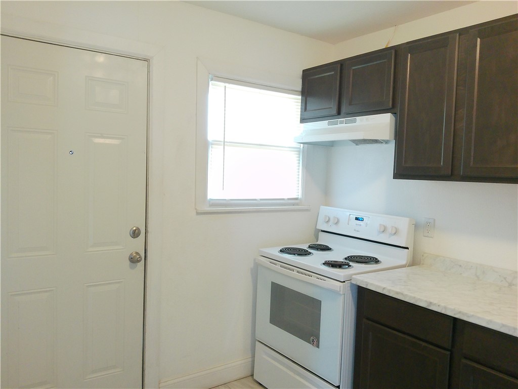 829 Indiana Avenue, Unit 2 Corpus Christi, TX 78404 - Photo 4 of 12 a kitchen with a stove and a microwave