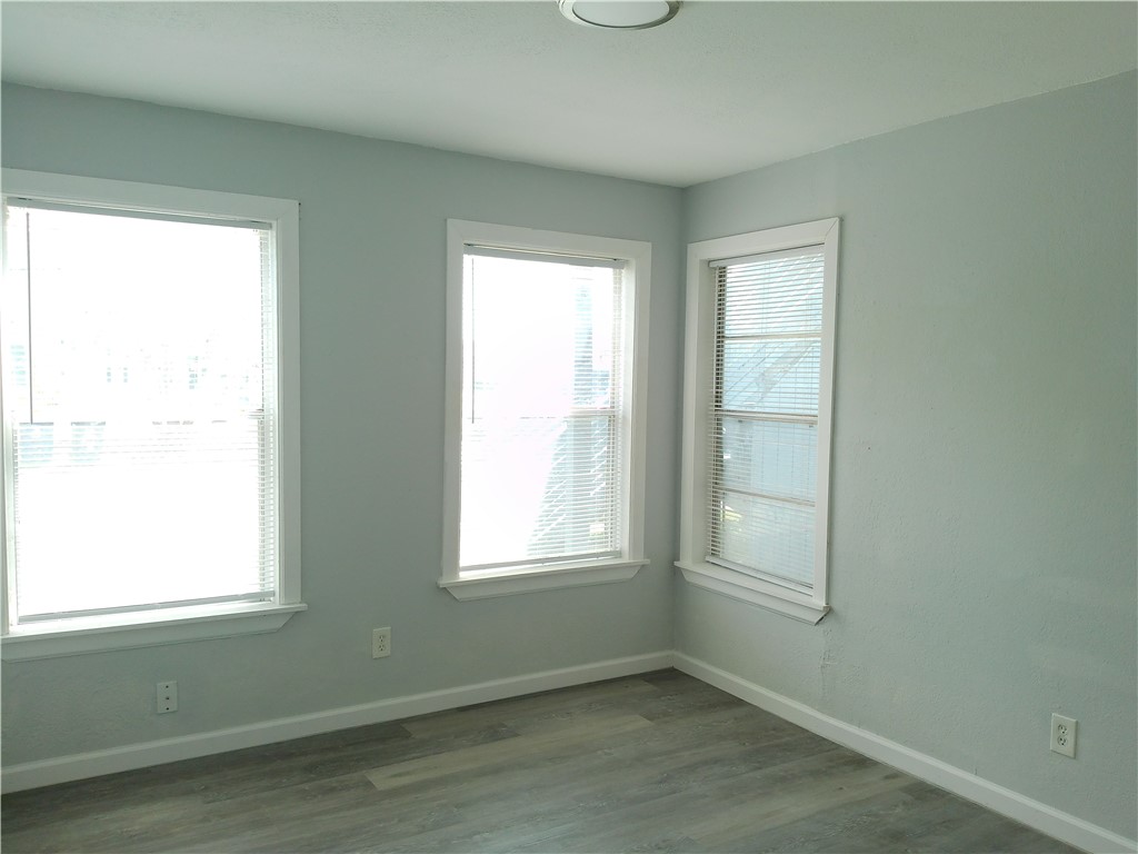 829 Indiana Avenue, Unit 2 Corpus Christi, TX 78404 - Photo 10 of 12 a view of an empty room with wooden floor and a window
