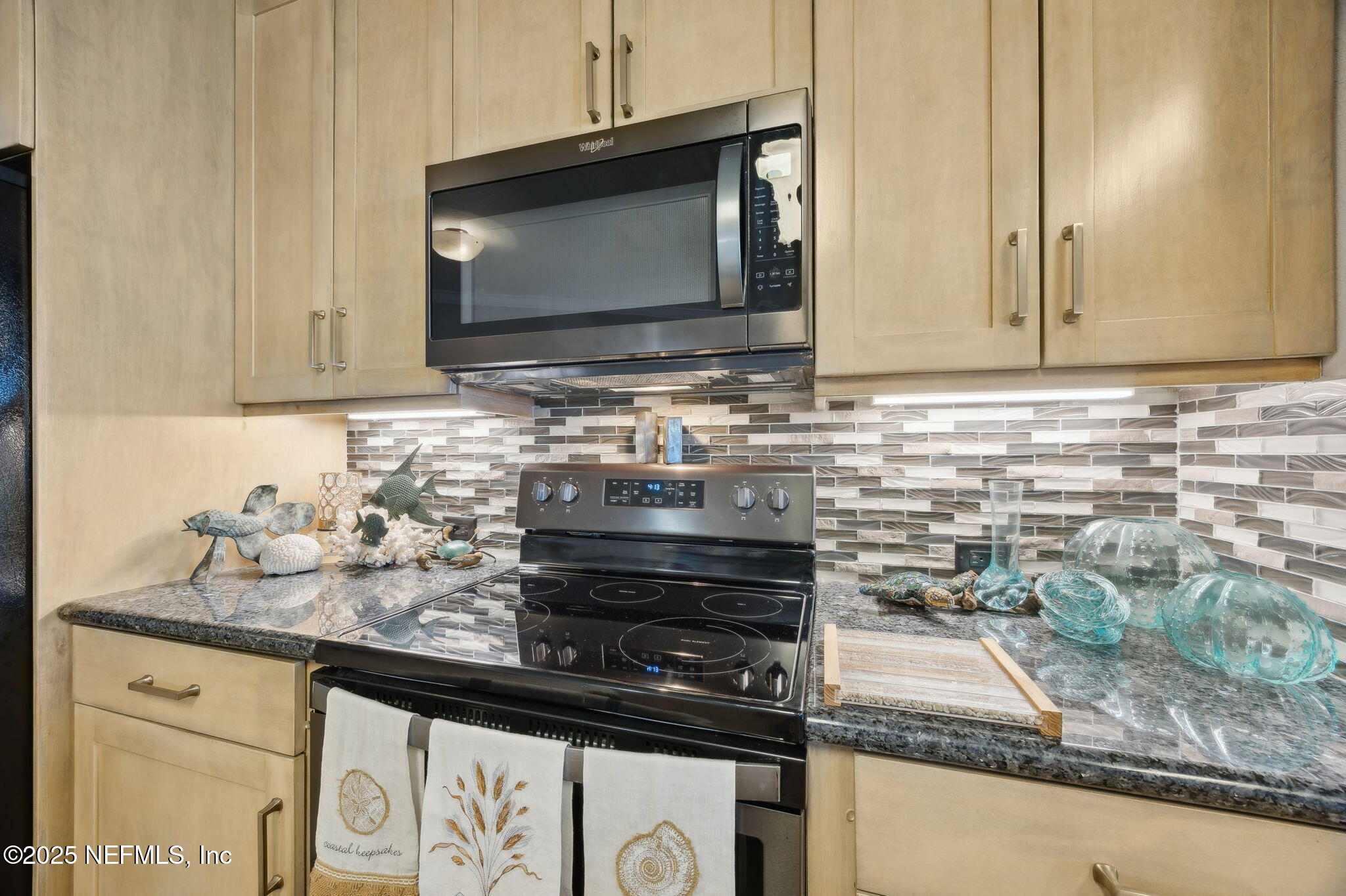 60 Surfview Drive, Unit 801 Palm Coast, FL 32137 - Photo 14 of 64 a kitchen with granite countertop a sink stove and microwave