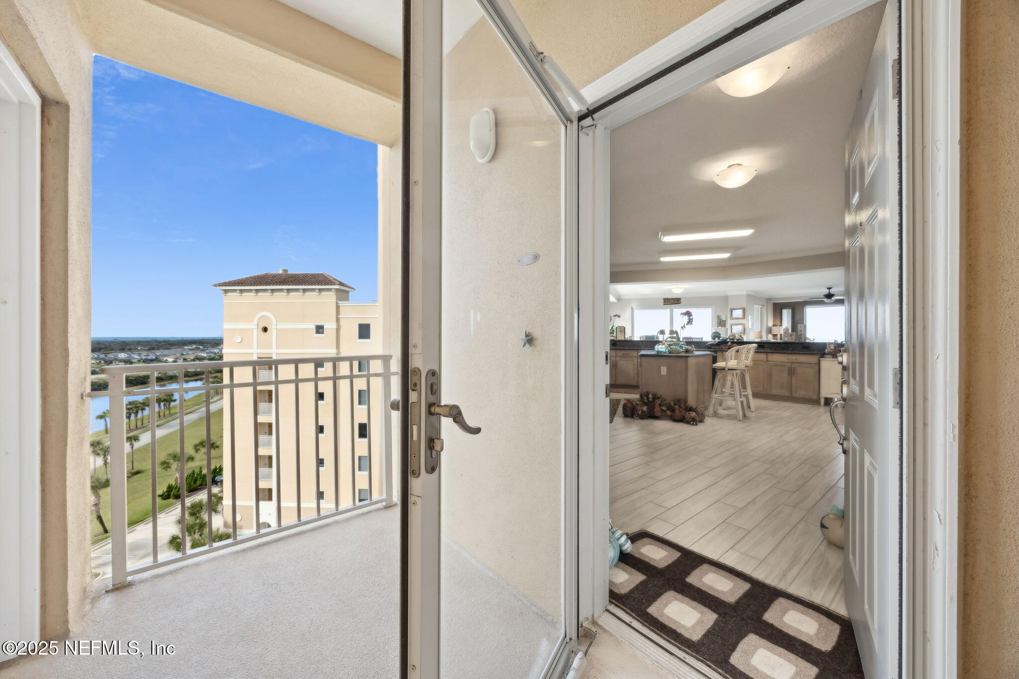 60 Surfview Drive, Unit 801 Palm Coast, FL 32137 - Photo 4 of 64 a view of a hallway with a dining table & chairs in a room